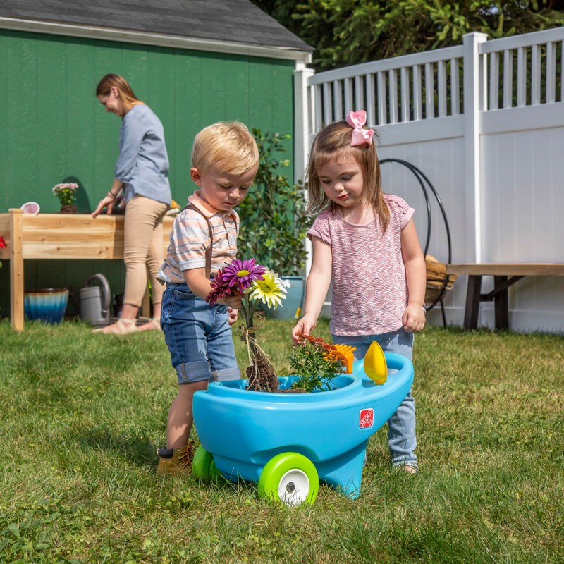 Springtime Wheelbarrow™ - Light Blue with children loading flowers