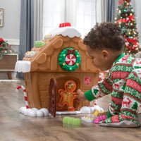 My First Gingerbread House™ with child playing with gingerbread boy