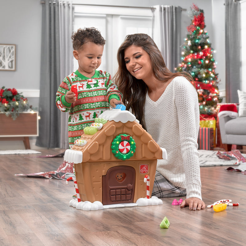 My First Gingerbread House™ child decorating the house